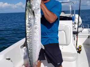 a person holding a fish on a boat